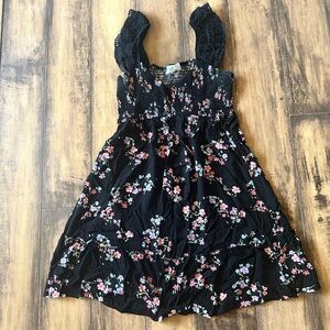 Black midi dress with floral detail and eyelet sleeves.